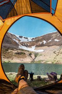 View from the tent, open tent with mountain views, trekking boots and freshly brewed coffee