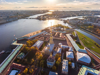 High angle view of city by sea against sky during sunset