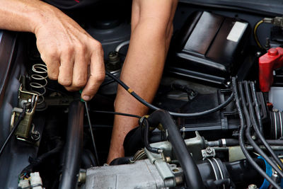 Cropped image of mechanic repairing car engine