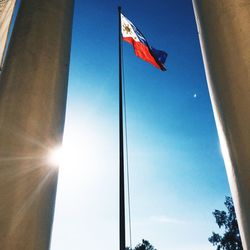 Low angle view of flags against blue sky