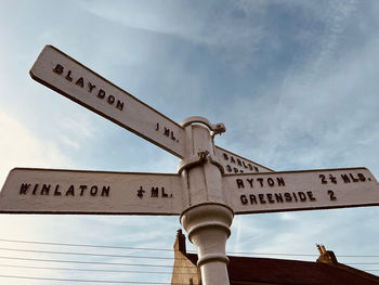 Low angle view of road sign against sky