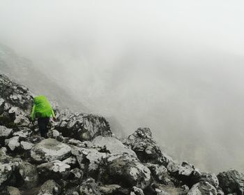 Rear view of person on rocks against mountains