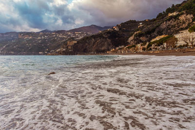 Scenic view of beach and mountains against sky