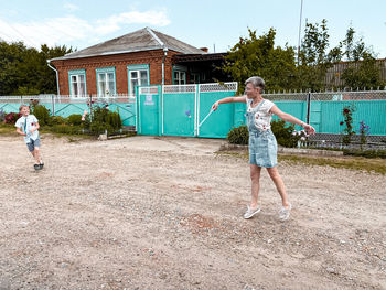 Full length of children against building
