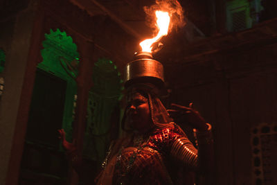 Portrait of woman dancing with fire pot