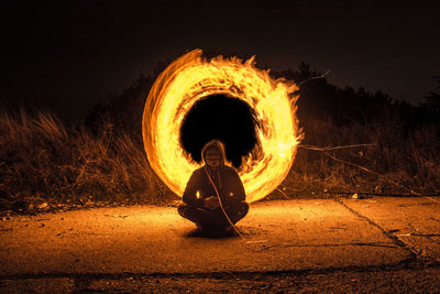 Blurred motion of man with fire crackers at night