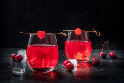 Cocktails with cherries. alcohol drinks on a black background, with ice. fancy beverage