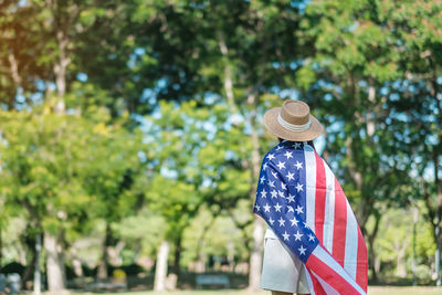 Rear view of woman wearing hat against trees