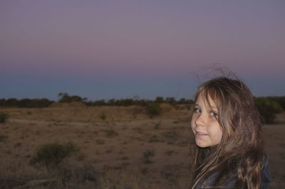 Portrait of young woman against clear sky