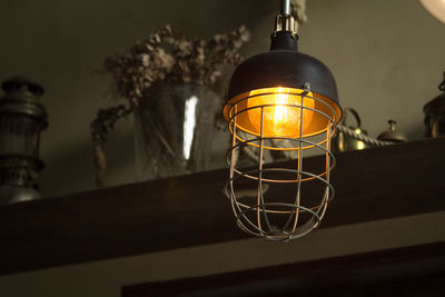 Low angle view of illuminated pendant light hanging from ceiling