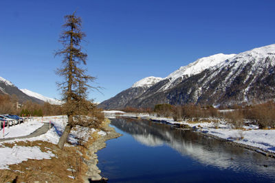 Scenic view of snowcapped mountains against clear blue sky
