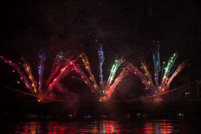 Firework display over river at night