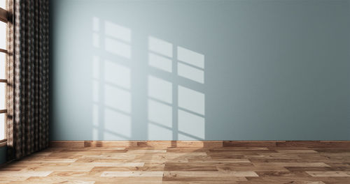 Empty wooden floor against wall at home