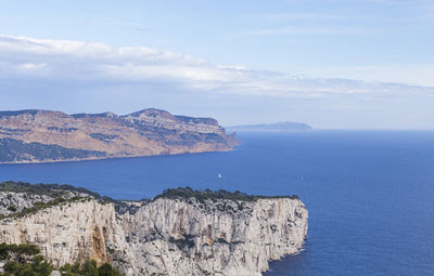 Scenic view of sea and mountains against sky