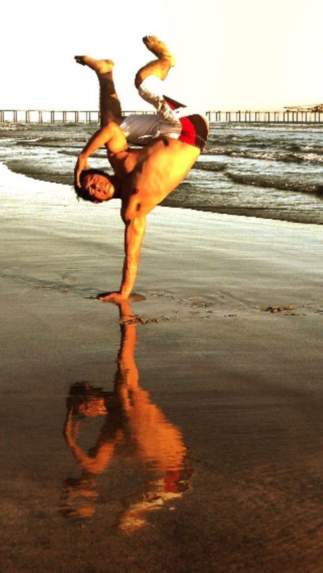 MAN JUMPING ON BEACH AGAINST SKY