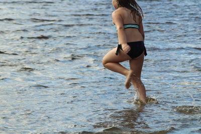 Rear view of girl running in sea