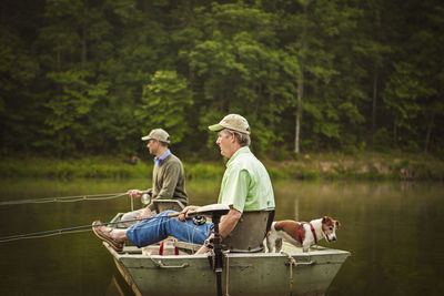 Side view of friends fishing in lake