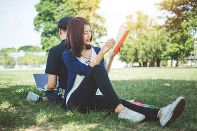 Full length of woman sitting on book