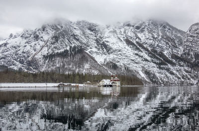 Scenic view of lake by snowcapped mountains during winter