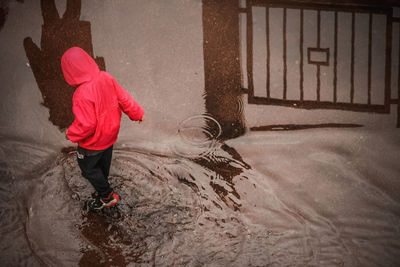 Rear view of girl standing on puddle