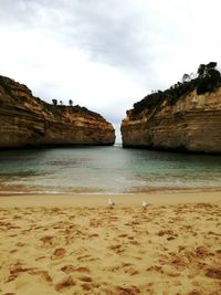 View of rocky beach against cloudy sky