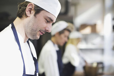 Side view of baker in kitchen at bakery