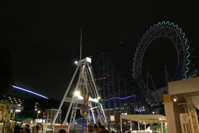 Low angle view of illuminated ferris wheel at night