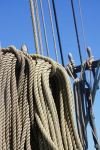 Low angle view of rope tied on ropes against sky