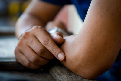 Close-up of man sitting on table