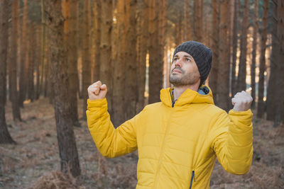 A man feels happy and makes a victory gesture in nature