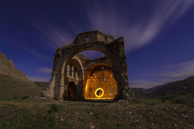 Old ruin on field against sky at night