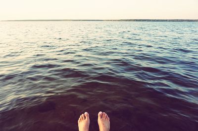 Low section of person relaxing in sea