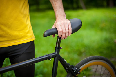 Cyclist with his bike, close up. outdoor photography. you can see his hands and the wheel.