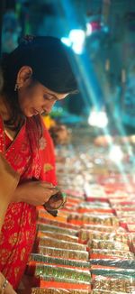 Side view of woman buying bangles at stall