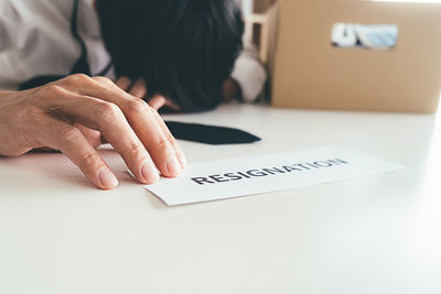 Midsection of woman with text on paper