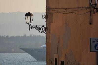 Street light by building against sky