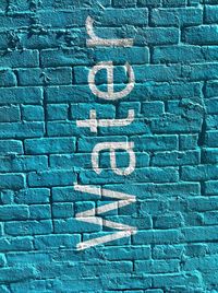 Water written on blue brick wall