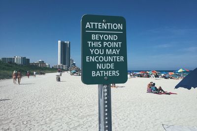 Warning sign of naked sunbathers on beach