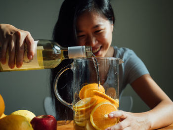 Smiling woman preparing drink