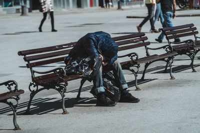 People sitting on bench in street