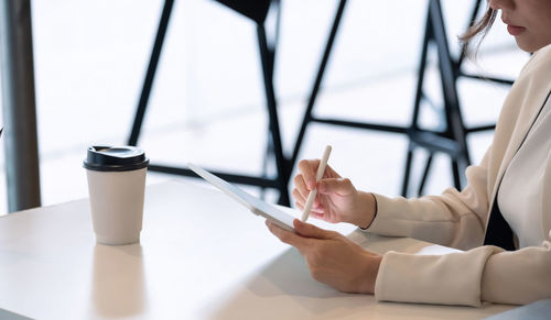 Midsection of woman using laptop on table