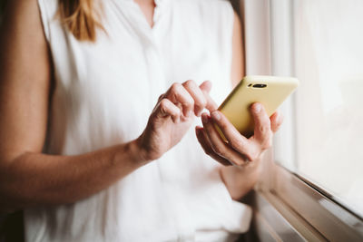 Midsection of woman using mobile phone