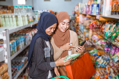 Portrait of smiling young woman standing in store