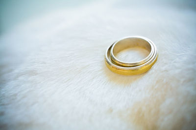 Close-up of wedding rings on white surface