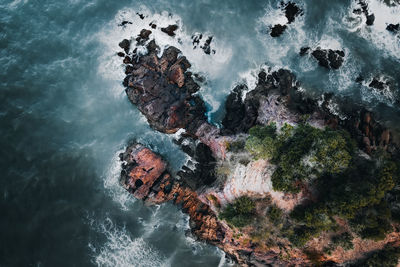 High angle view of rocks in sea against sky