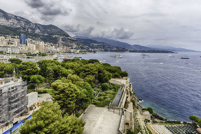 High angle view of city by sea against sky