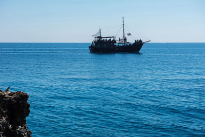 Pirate ship sailing in the sea. view from inside a cave