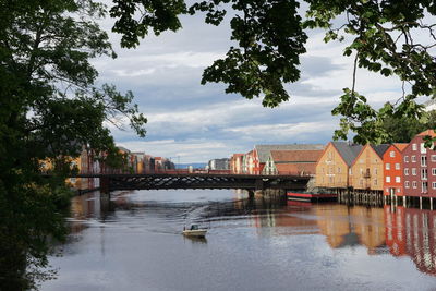 Bridge over river in city against sky