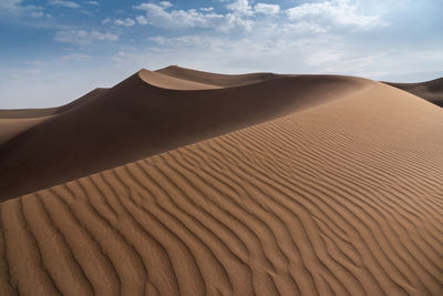 Sand dune in desert against sky