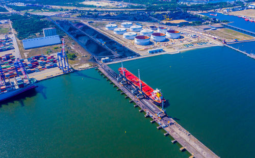 Loading coal anthracite mining in port on cargo tanker ship with crane bucket of train. aerial view.